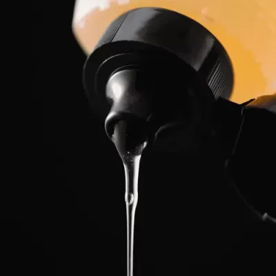 Frasco amarelo com tampa preta a despejar líquido transparente