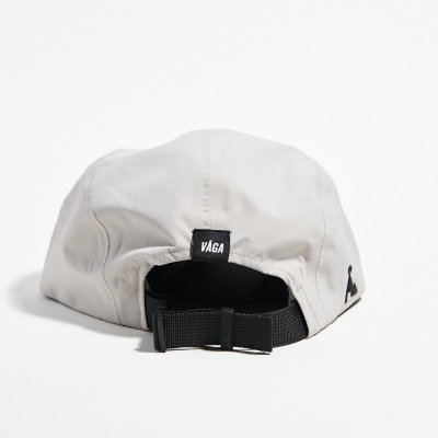 Boné cinzento claro com fecho preto e etiqueta VAGA