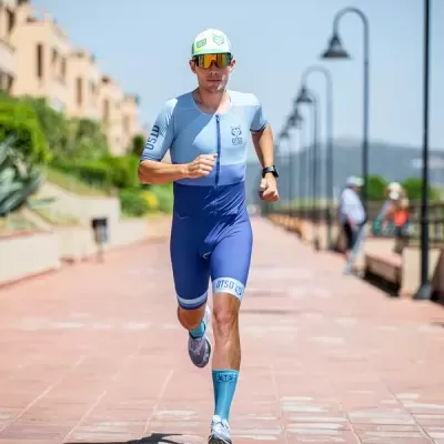 Homem a correr com roupa desportiva azul e boné branco