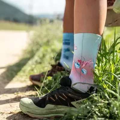 Meias desportivas brancas com padrão colorido e sapatilhas pretas ao ar livre