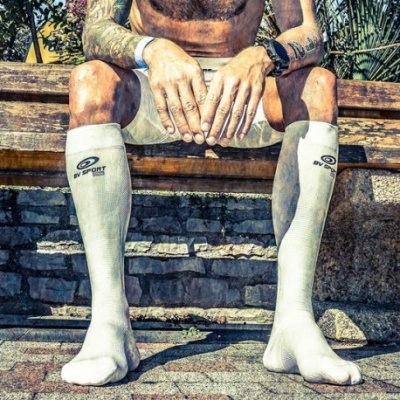 Meias desportivas brancas GV SPORT numa pessoa sentada num banco ao ar livre