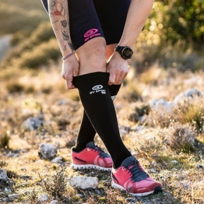 Pessoa a calçar meias altas pretas BW SPORT e ténis cor-de-rosa em ambiente exterior