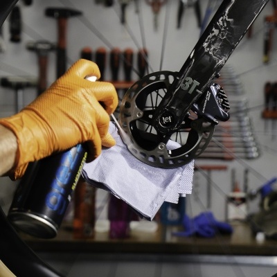 Spray para limpeza de disco de travão em roda de bicicleta preta na oficina