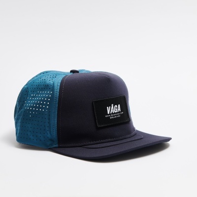 Boné azul escuro e azul claro com etiqueta preta e texto VÁGA WEAR & SUPPLY
