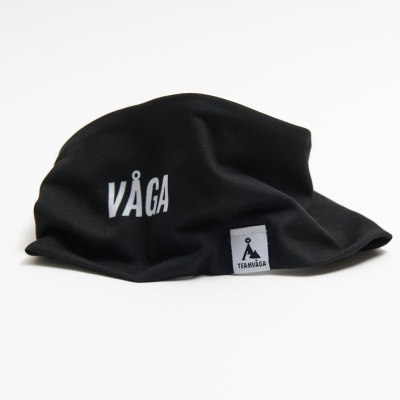 Máscara preta com texto branco VÅGA e etiqueta branca com logotipo preto