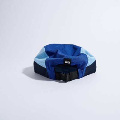 Boné azul em tecido tipo malha com ajuste traseiro preto e etiqueta preta com texto VÁGA.