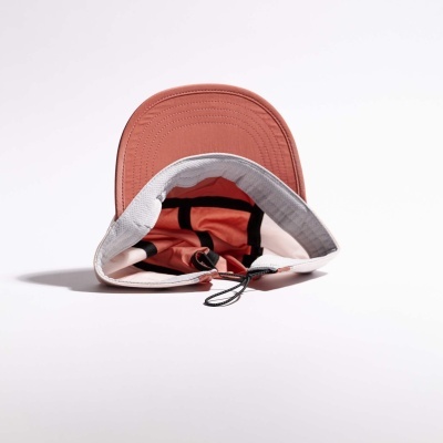 Boné desdobrável vermelho e branco com aba e cordão ajustável.