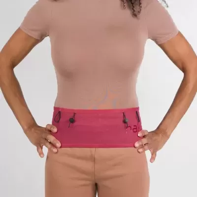 Cinto desportivo vinho com cordões ajustáveis usados com t-shirt bege e calções castanhos.