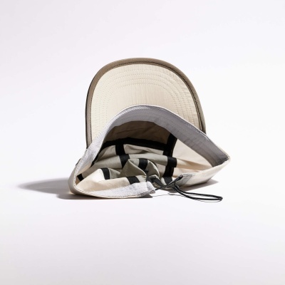 Interior de boné bege com aba castanha e tira de ajuste branca com cordão preto