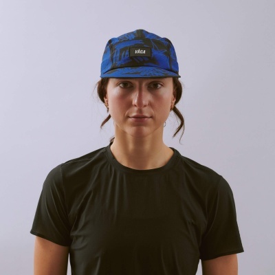 Boné azul e preto com etiqueta VÅGA numa pessoa com t-shirt preta
