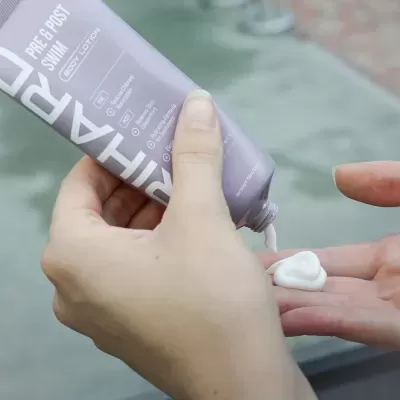 Pessoa a aplicar creme branco de bisnaga lilás