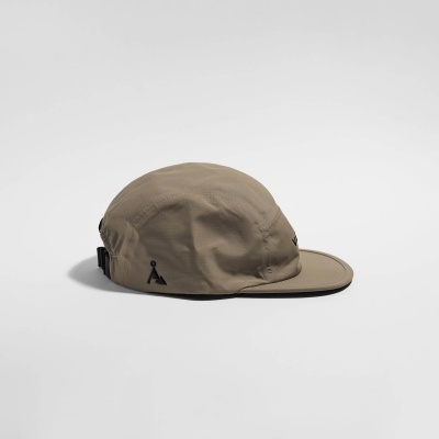 Boné bege claro com aba reta e logótipos pretos sobre fundo branco.