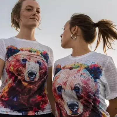 Duas mulheres com t-shirts brancas de malha estampadas com urso colorido
