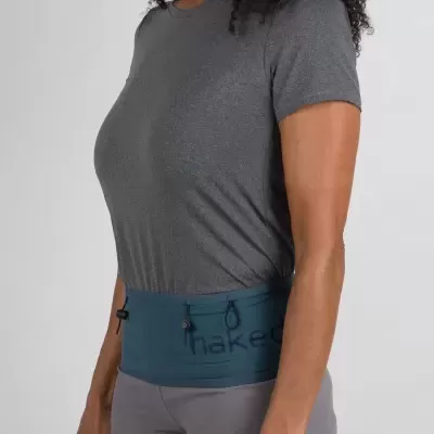 Mulher com t-shirt cinzenta e calções de cintura azul com texto 'naked'