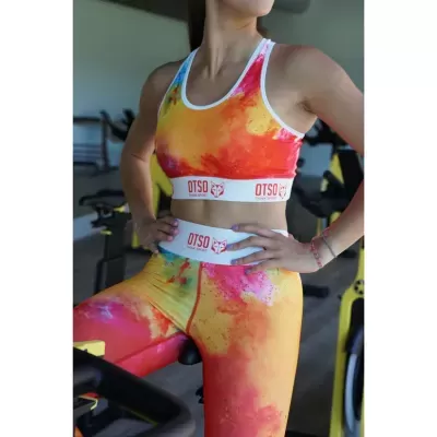 Conjunto desportivo colorido com inscrição OTSO numa pessoa num ginásio