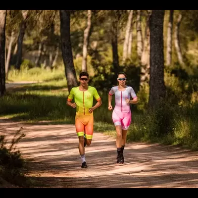 Dois corredores a correr num caminho de terra numa floresta