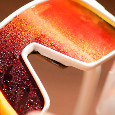 Peça decorativa com contorno branco e preenchimento vermelho e laranja com gotas de água