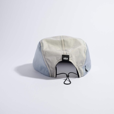 Boné creme e azul claro com fecho de cordão e etiqueta VÁGA