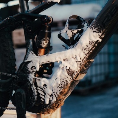 Bicicleta de montanha preta com espuma de limpeza aplicada no quadro