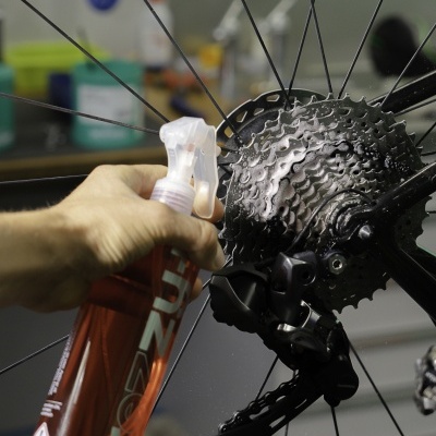 Frasco de spray a limpar roda traseira de bicicleta