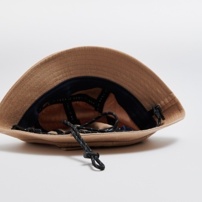 Chapéu bege com cordão preto em fundo branco