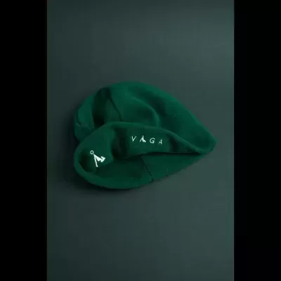 Gorro verde escuro com bordados brancos sobre fundo cinza escuro