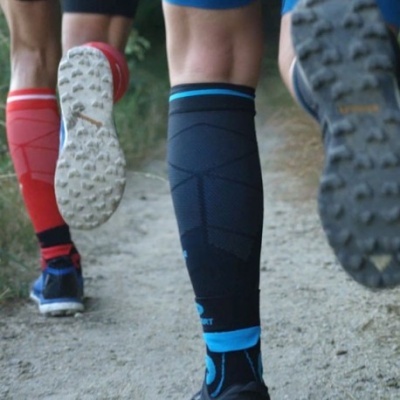 Pessoas a correr com meias compressivas em vermelho e preto