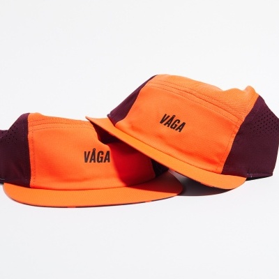 Dois bonés laranja e bordo com texto VAGA em fundo branco