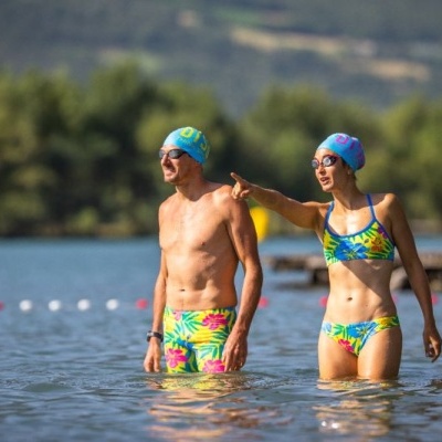 Casal a usar fatos de banho tropicais coloridos em água exterior