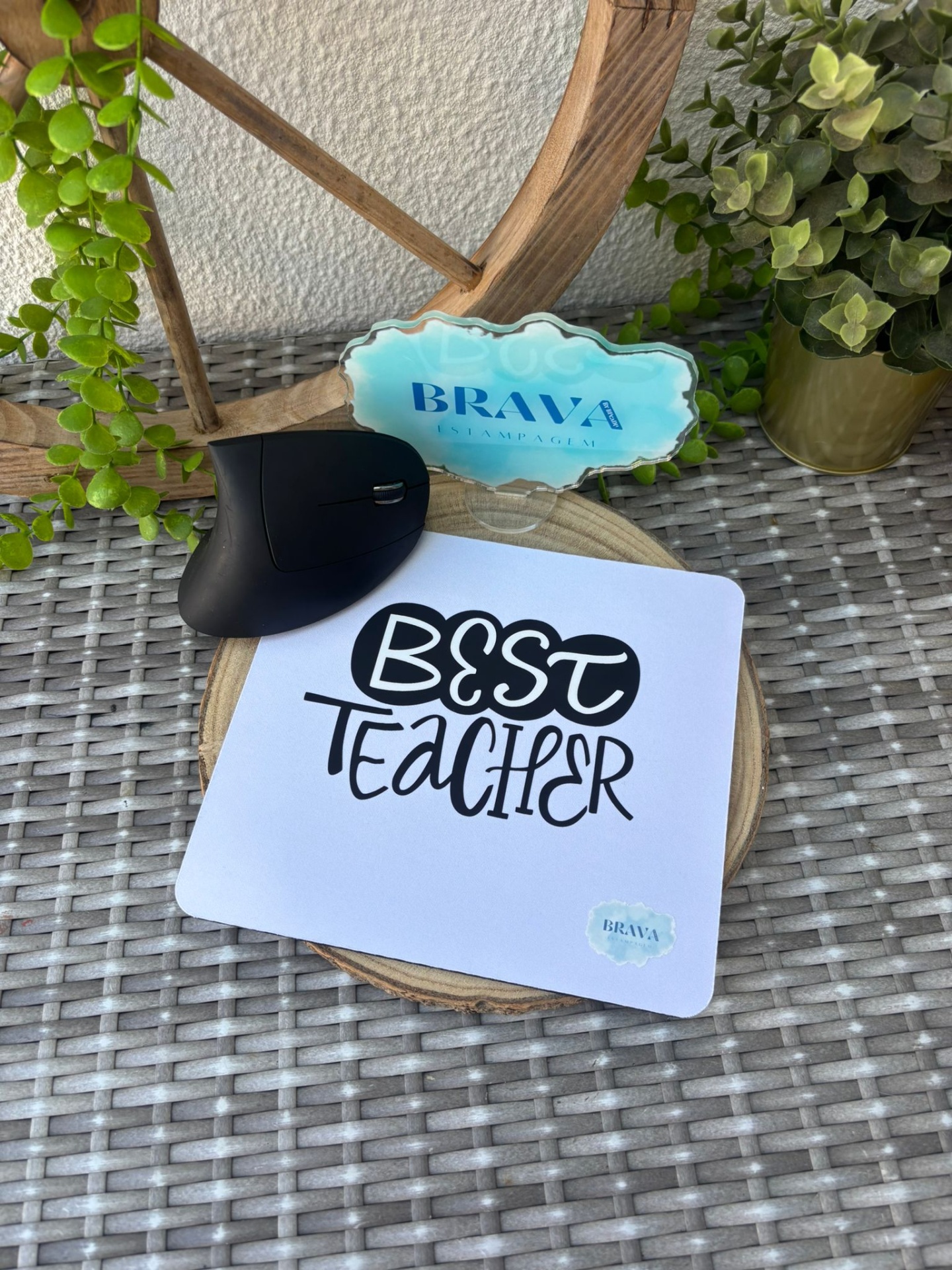 Base para Rato PC Tapete de rato branco com texto BEST TEACHER e selo azul sobre mesa com rato preto e plantas