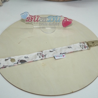 fita de tecido com clip bege sobre base redonda de madeira clara e placa de acrílico