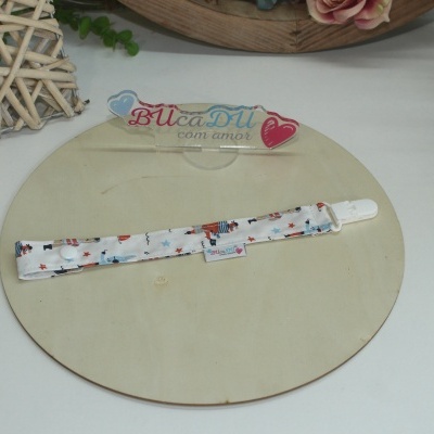 Prendedor de chupeta branco com padrão colorido sobre suporte de madeira clara