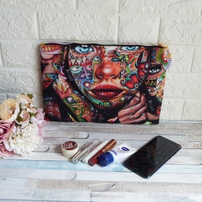 Bolsa tecido colorida com rosto estampado, flores artificiais, produtos maquilhagem NIVEA, telemóvel Huawei