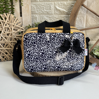 Bolsa padrão animal preto e branco com alça preta e laço pendurado