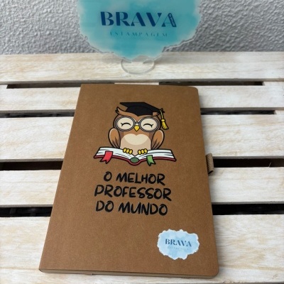 Caderno castanho com coruja e texto para professor, junto a suporte acrílico azul