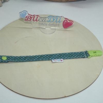 Pulseira azul com bolinhas brancas e fecho verde sobre fundo claro