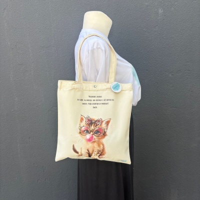 Saco de tecido creme com ilustração de gato a assoprar rebuçado e texto em português
