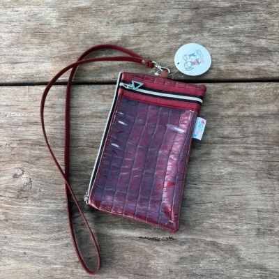Carteira vermelho escuro com padrão pele de crocodilo, zip, bolso transparente e cordão.