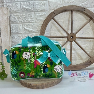 Bolsa infantil retangular com padrão verde e desenhos de animais coloridos com alças azul-turquesa