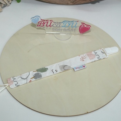 Prendedor de chucha em tecido branco com padrão colorido e clip branco