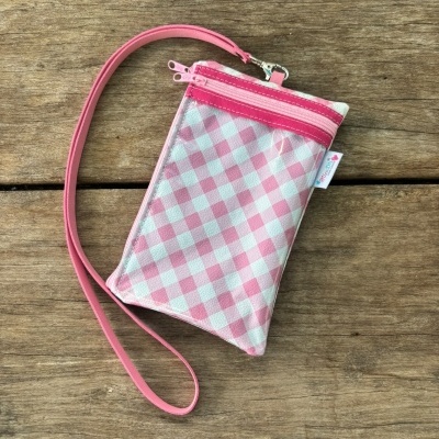Bolsa pequena xadrez rosa e branca com alça fina e fecho de correr rosa