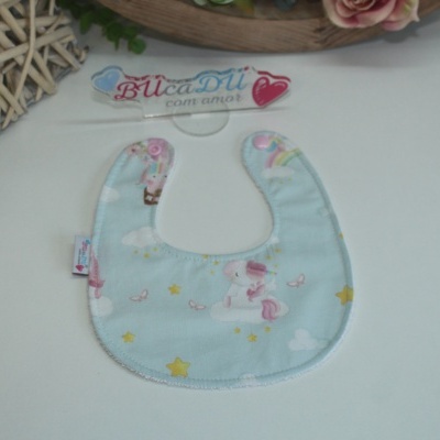 Babete azul claro com padrão de unicórnios e estrelas sobre fundo branco