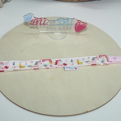 Tira de tecido estampado com padrão de unicórnios e castelos e presilha rosa