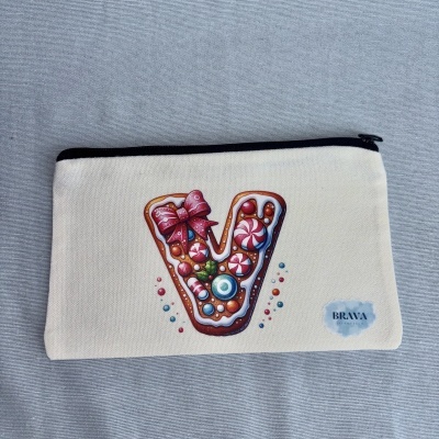 Estojo branco com fecho preto e decoração de letra V em estilo biscoito colorido