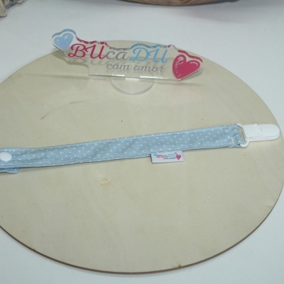 Prendedor de chupeta azul claro com padrão de pontos brancos e etiqueta BUcaDU com amor