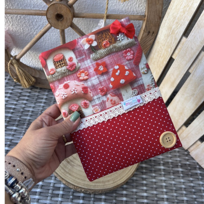 Capa de tecido vermelha com padrão de cogumelos e flores bordadas e detalhes decorativos