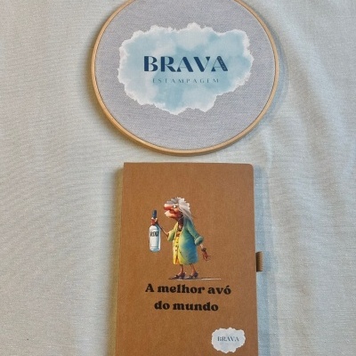 Moldura redonda de tecido com escrita e caderno castanho com desenho e frase