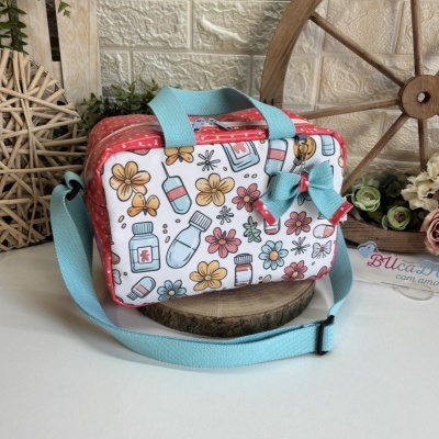Bolsa pequena com padrão colorido de flores, comprimidos e frascos, alça azul clara