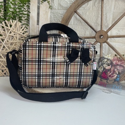 Mala pequena com padrão xadrez e laço preto numa superfície branca