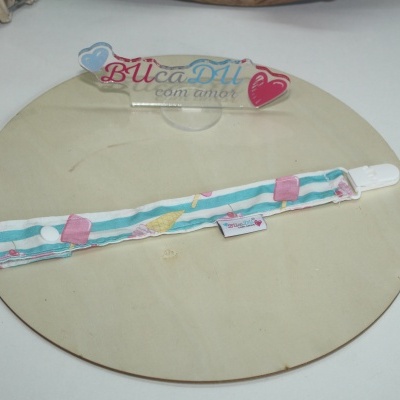 Pulseira ou tira de tecido com padrão de gelados coloridos em azul, rosa e branco sobre placa de madeira clara